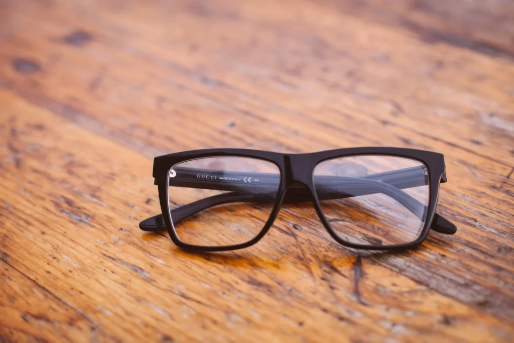 Glasses with black frame on top of a wood colored surface